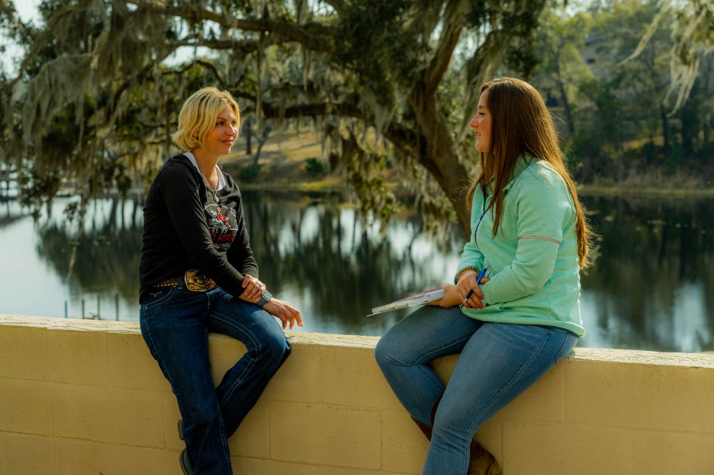 Kristen and client talking lakeside at Red Bird Farm